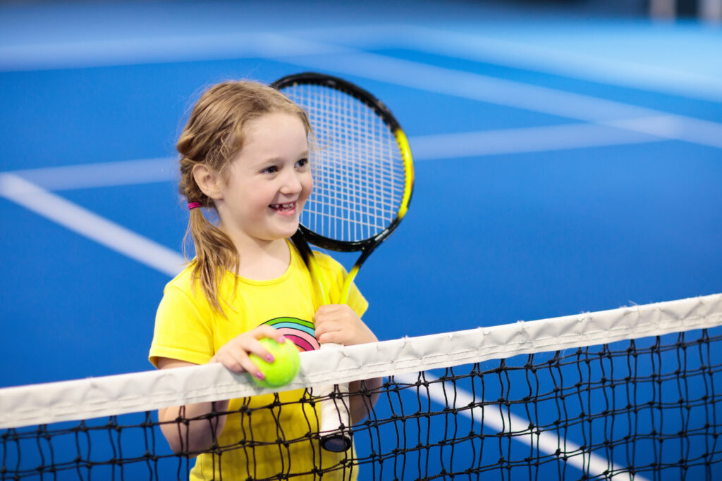 child playing tennis on indoor court